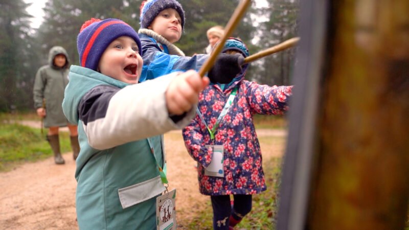 Children wave their sticks on the Stick Man activity trail