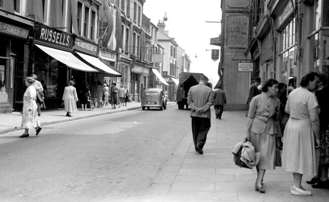 Black and white photograph showing a street scene