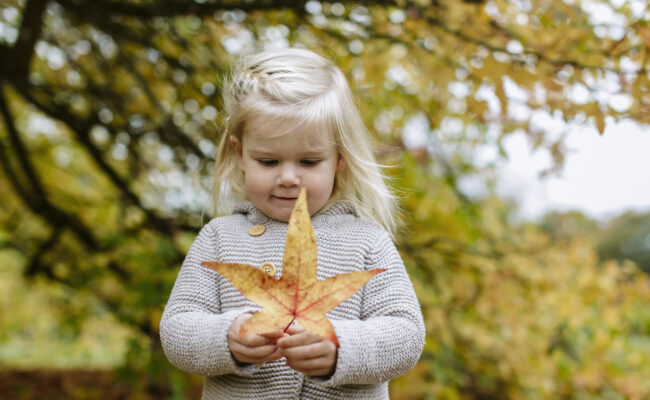 Little girl with big leaf