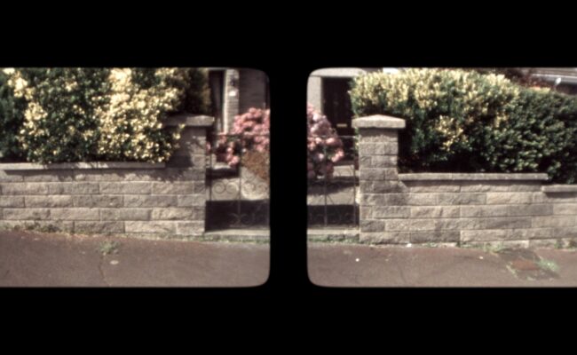 Still from a film showing the front garden of a house